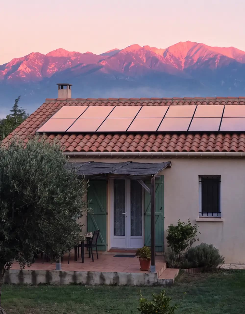 Maison équipée de panneaux solaires face au Canigou rosi par l’aube